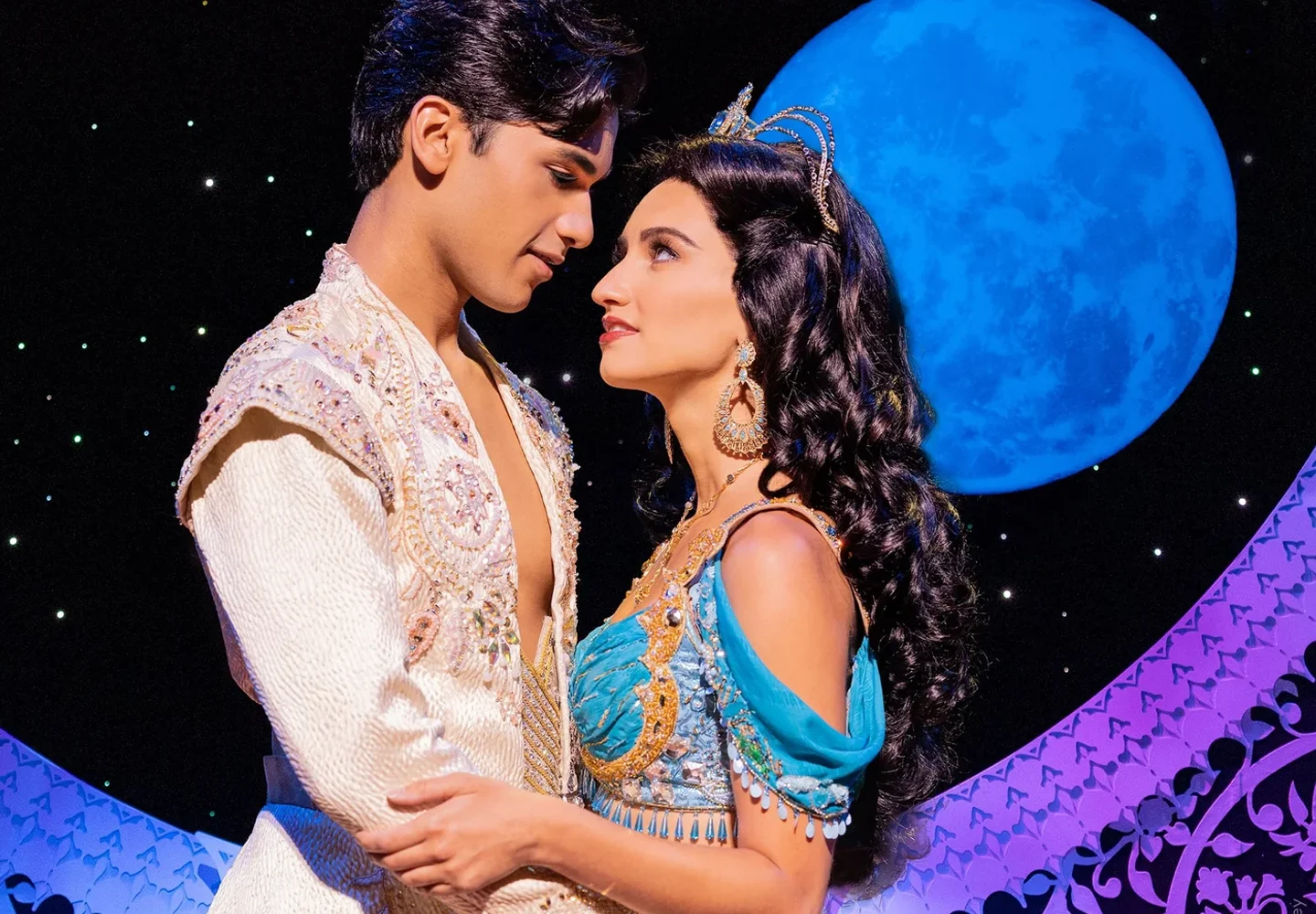 Aladdin and Jasmine facing each other against a starry stage backdrop