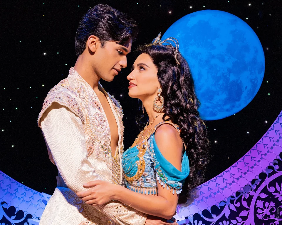 Aladdin and Jasmine facing each other against a starry stage backdrop