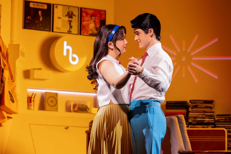 Maybe Happy Ending performers together in a yellow-lit room
