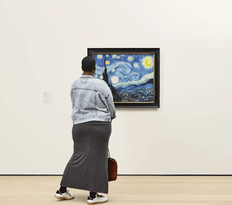 Visitor looking at a star-filled night painting in a MoMA gallery