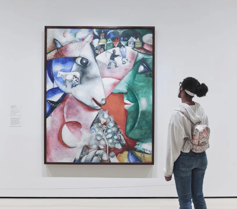 Visitor studying a colourful modern painting at MoMA