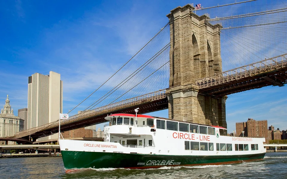 Circle Line sightseeing boat beside the Brooklyn Bridge