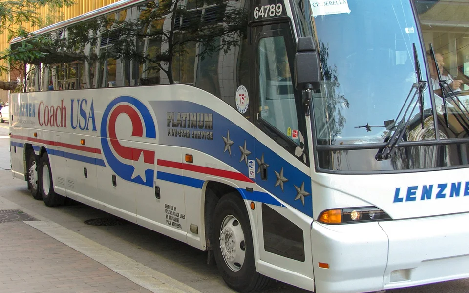 Coach USA airport coach parked at a city stop