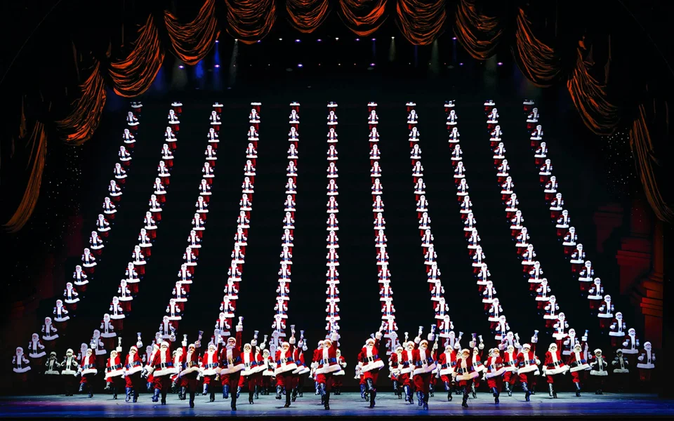 Rockettes forming a Christmas tree shape across the Radio City stage