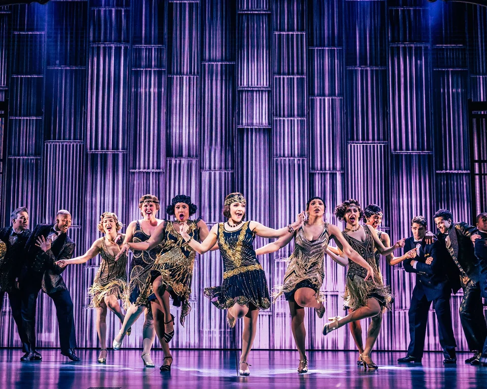 The Great Gatsby dancers performing before an Art Deco stage design