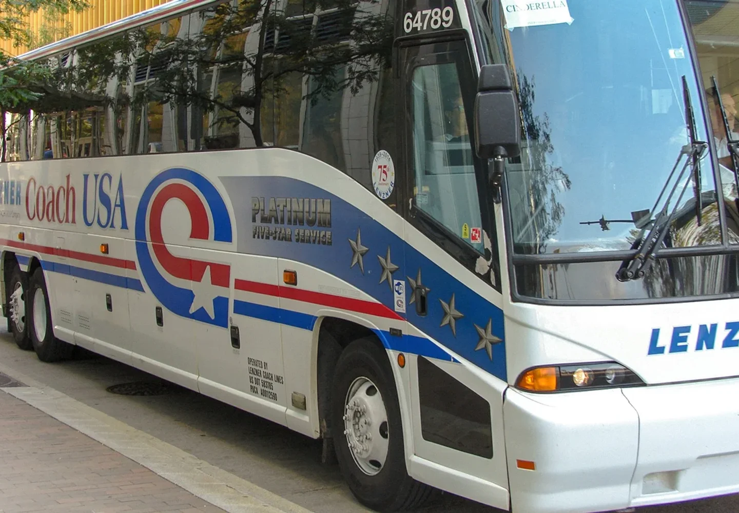 Coach USA airport coach parked at a city stop